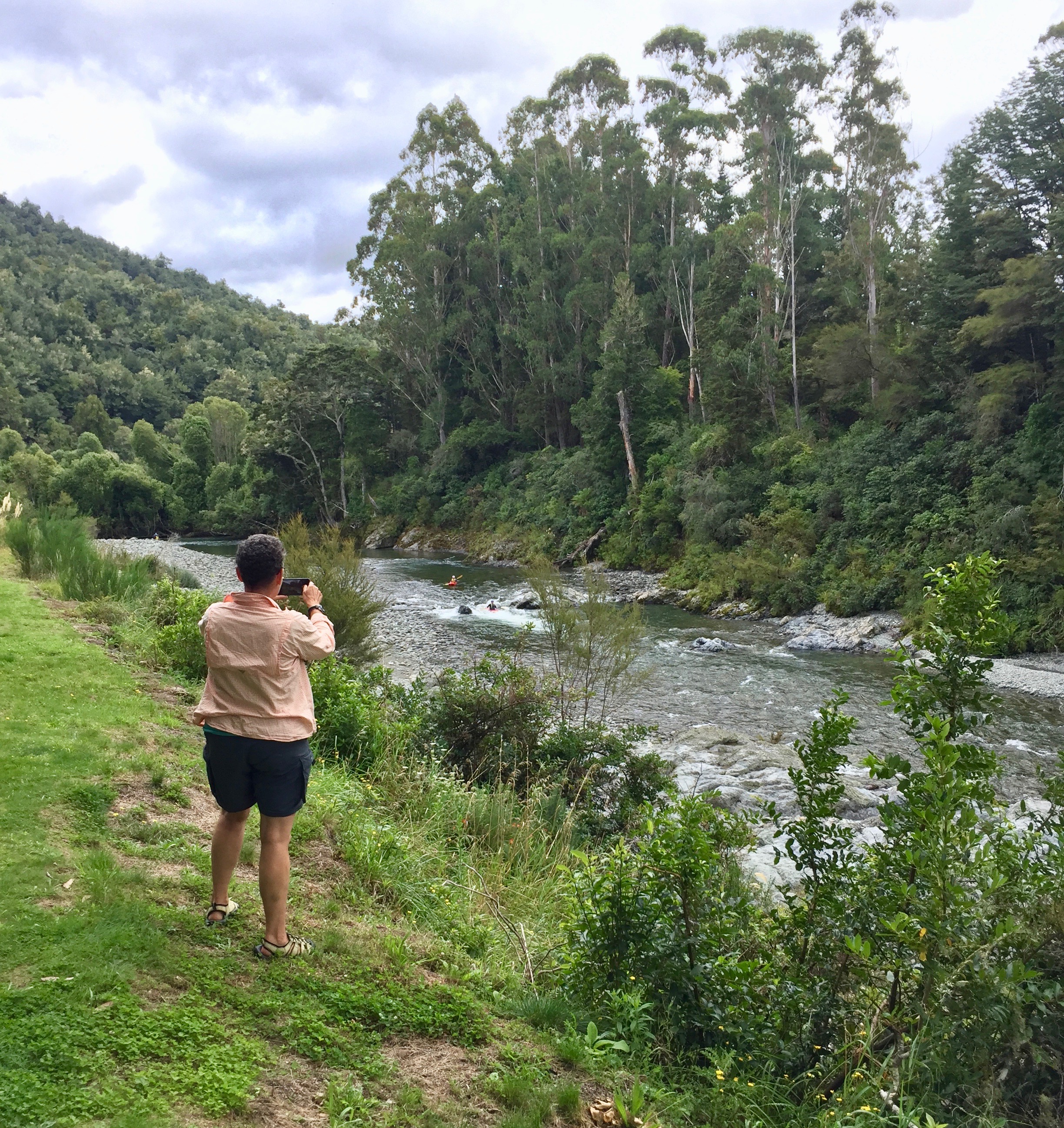 Camille taking a picture of some kayakers  on the Pelorus River